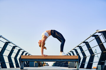 Pretty young woman doing yoga exercise on the nature in the morning.