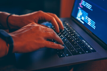 The code is on a laptop on a wooden table in front of the window  in the dark with a view of the...