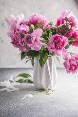 Fototapeta na wymiar Fresh Peony flowers in vase. bouquet close up. Stylish floral greeting card.