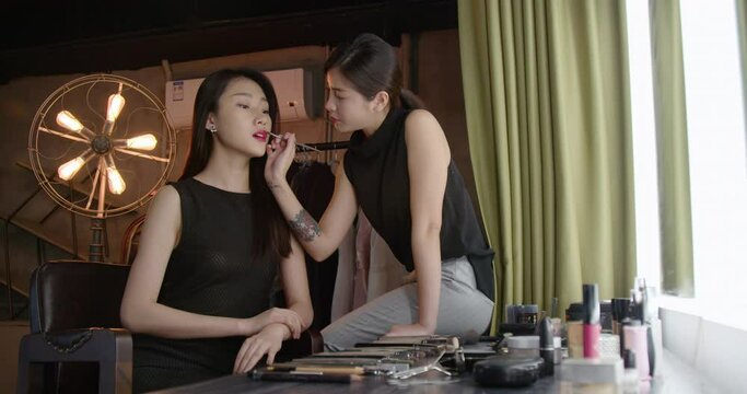 Makeup artist applying makeup on model,4K