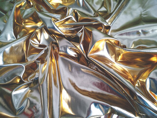 A luxury of soft gold. Abstract flashing background. Gold fabric texture, luxurious crumpled folds of gold leather