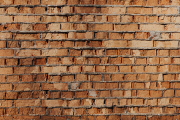 Wall of old orange clay bricks. Ruined vintage stone background. Rough aged masonry backdrop. Surface of grunge brick texture for design and decoration. Loft style for exterior and interior decoration