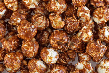 Heap of delicious popcorn covered with milk chocolate on white background. A pile of popcorn texture background.