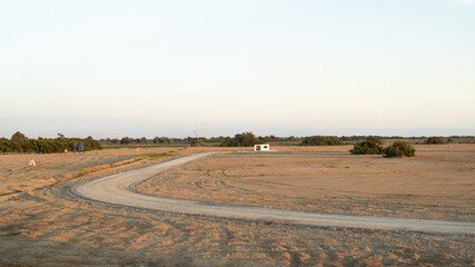 Fototapeta premium little house in the desert and dirt road, sunny day beautiful summer landscape, blue sky
