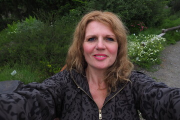mature woman taking a selfie in the park 