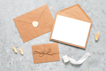 Wedding invitation card template. Blank greeting card mockup, brown envelopes and dried grass....
