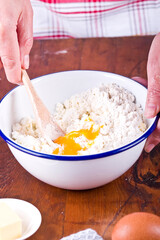 Making a shortcrust pastry adding egg to the flour