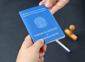 Person giving Brazilian Work card to another person. Signed work card (carteira assinada). 