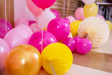 Pink and white baloons at reception hall.Balloons filled with helium,white and gold colors,tied with golden ribbons.Flying balls, as an essential accessory for celebrating birthday and other holidays.