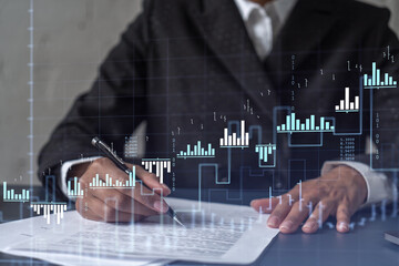African American businesswoman in formal wear is signing the contract to invest money in stock market. Internet trading and wealth management. Forex and financial hologram chart.