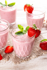 Fresh healthy strawberry smoothie on wooden background
