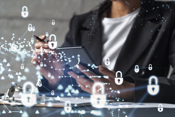 Businesswoman in formal wear signing the contract to prevent probability of risks in cyber security. Checking the phone. Padlock Hologram icons over the working desk.
