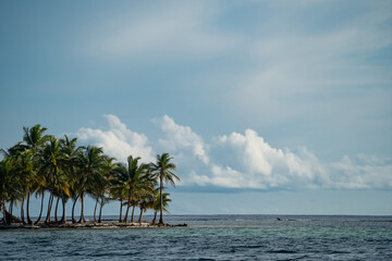 Small tropical island with coconut palm trees and white sand beach. Vacation and travel concept 