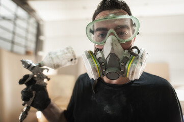 Funny Worker. Worker posing with air brush painter varnish