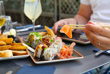 Man holding chopsticks eating fresh salmon sashimi. Man eating salmon sashimi in japanese restoran.