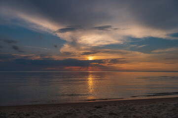 sunset in the sea with clouds and calm water