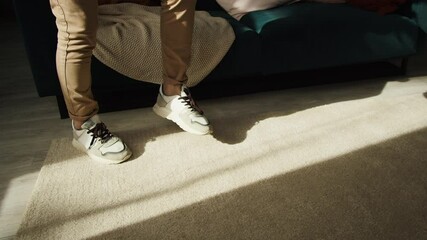 Close-up of young sportsman legs minting a soccer ball, professional football player training in the living room at home, football fan doing sport during coronavirus covid 19 lockdown. - Powered by Adobe