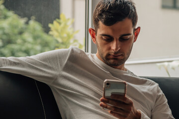 man at home sitting on the sofa with mobile phone