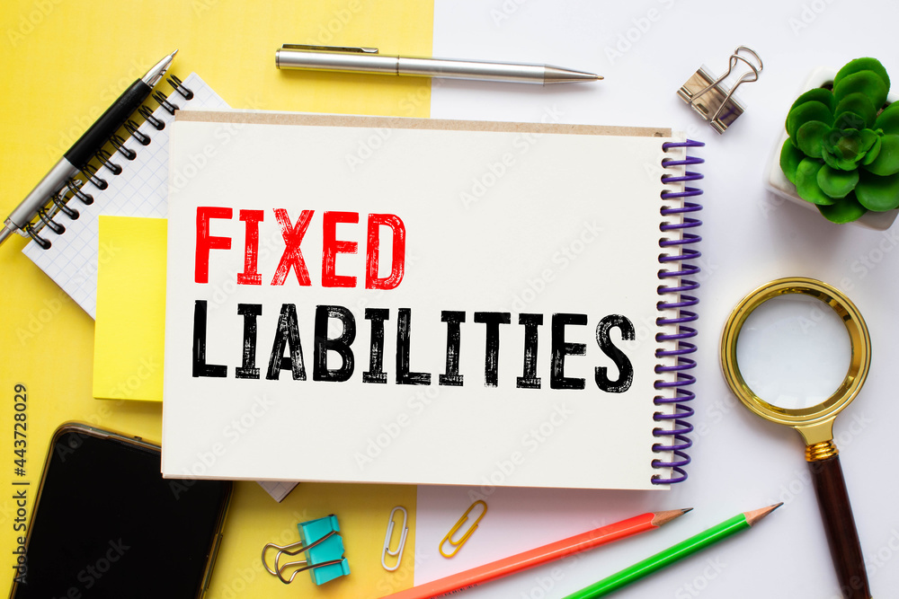 Poster asset liability text written on a notebook with pencils