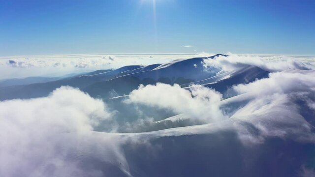 An extraordinary mountain valley covered with fluffy clouds at winter sunset
