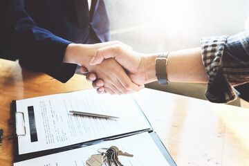 Focus on the congratulatory handshake. The real estate agent agrees to buy the home and hand the...