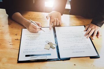 Obraz premium estate agent gives pen and documents agreement with customer to sign contract. Concept agreement.