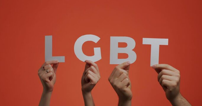 Lgbt culture, gender rights concept. Hands raising up showing lgbt sign made of carved paper for blogging 