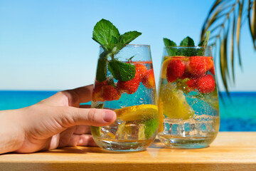 Female hand with hard seltzer cocktail. Summer cocktails, beach bar concept. 
