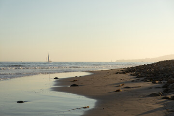 sunset on the beach, Pacific ocean with a yacht in the distance, Santa Barbara, California