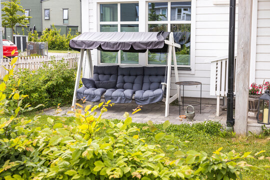 View of cute swing chairs on backyard of private house. Sweden.