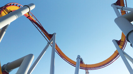 Empty twisting roller coaster tracks against blue sky