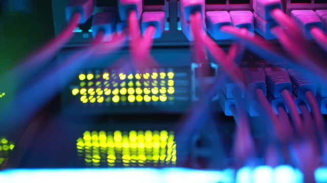 Close up fiber optic in server room. Network cables installed in the rack at data center. Ethernet cable on network switches background