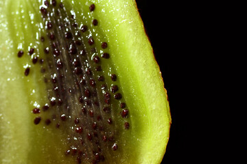 Green Kiwi texture. It have rows of tiny, black, edible seeds inside.