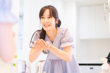 家で洗顔をする若い女性