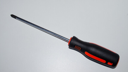 Close up of black and red phillips screwdriver isolated on white background.