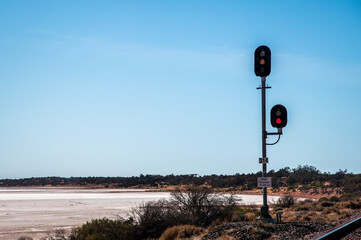 Traffic lights on the trains tracks passing the salt plains in South Australia outback.