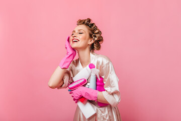 Portrait of charming housewife with detergent on pink background
