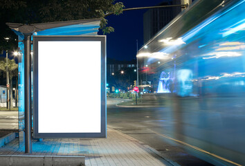 Billboard with light in the city center at night, with bus in motion