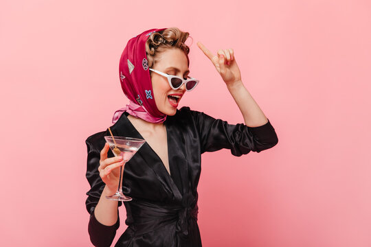 Elegant Girl In Silk Scarf And Glasses Holding Martini Glass On Pink Background