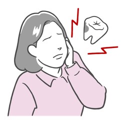虫歯が痛くてほっぺたを押さえる若い女性