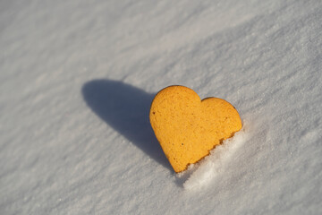 Fototapeta premium Heart shaped xmas cookie on a white snow in winter
