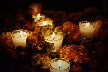 Velas rodeadas por flores en la noche de día de muerto México