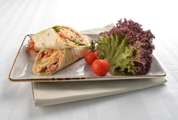 western tortilla wrapped with ham, cheese and vegetables in white background halal breakfast menu