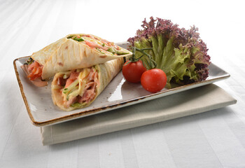 western tortilla wrapped with ham, cheese and vegetables in white background halal breakfast menu