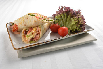 western tortilla wrapped with ham, cheese and vegetables in white background halal breakfast menu