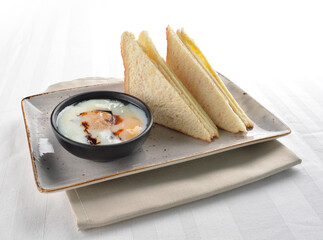 French toast bread roti in kaya and butter jam with half boiled egg in bowl white background asian halal breakfast menu