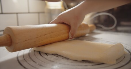 Close up hands of bakery Chef preparing kneading roll out dough with a rolling pin on the table, Ingredients and preparation stages for cooking making bread cake at kitchen	

