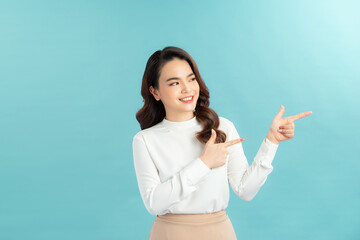 Young asian woman over isolated background smiling and looking at the camera pointing with two hands and fingers to the side.