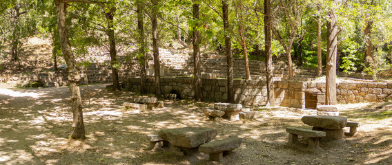 Picnic area with stone tables and chairs to sit in natural park.