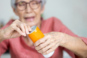 Old elderly with hands and fingers problems,can not pull the tab of beverage can,unable or hard to open,fingers do not have the strength to pry the tin lid or difficult to pick up handle the pull tab - obrazy, fototapety, plakaty